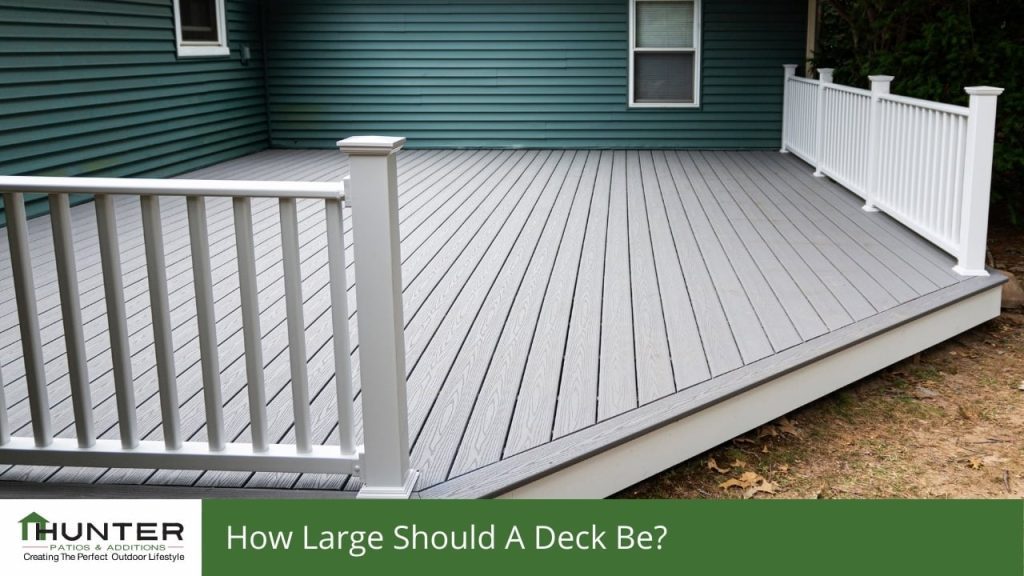 FAQs about Decking in Newcastle - Deck Spacious backyard deck with white railing.