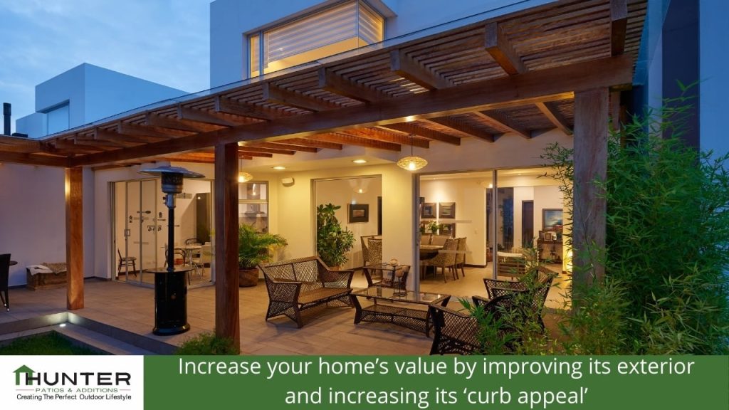 Increase your home’s value by improving its exterior and increasing its ‘curb appeal’ Modern patio with pergola and outdoor furniture.