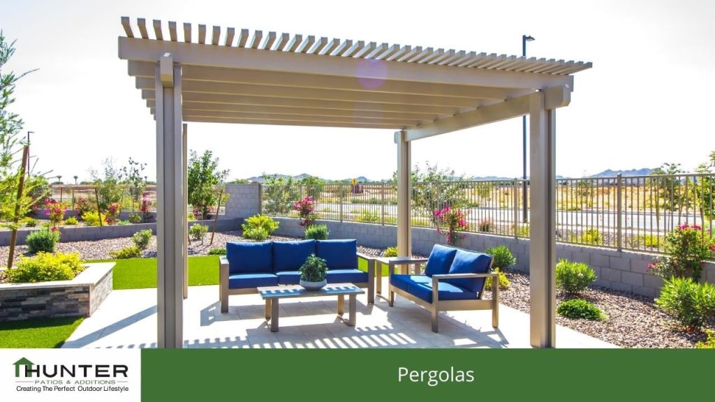 Pergolas Wooden pergola with outdoor seating and garden view.