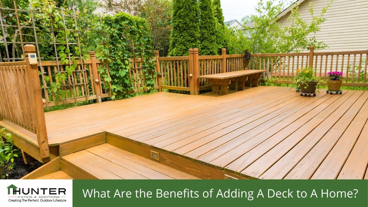 Wooden deck with greenery and bench seating.