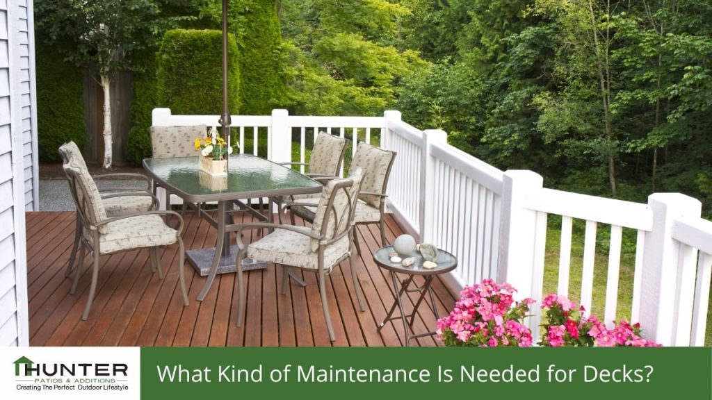 FAQs about Decking in Newcastle - Deck Outdoor deck with table, chairs, and garden view.
