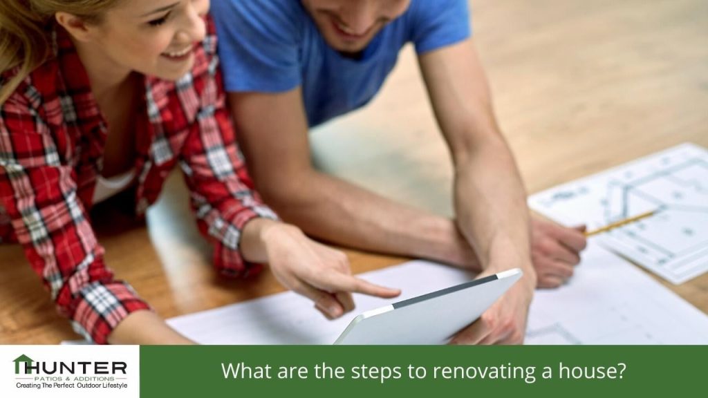 What are the steps to renovating a house Couple reviewing house renovation plans on tablet