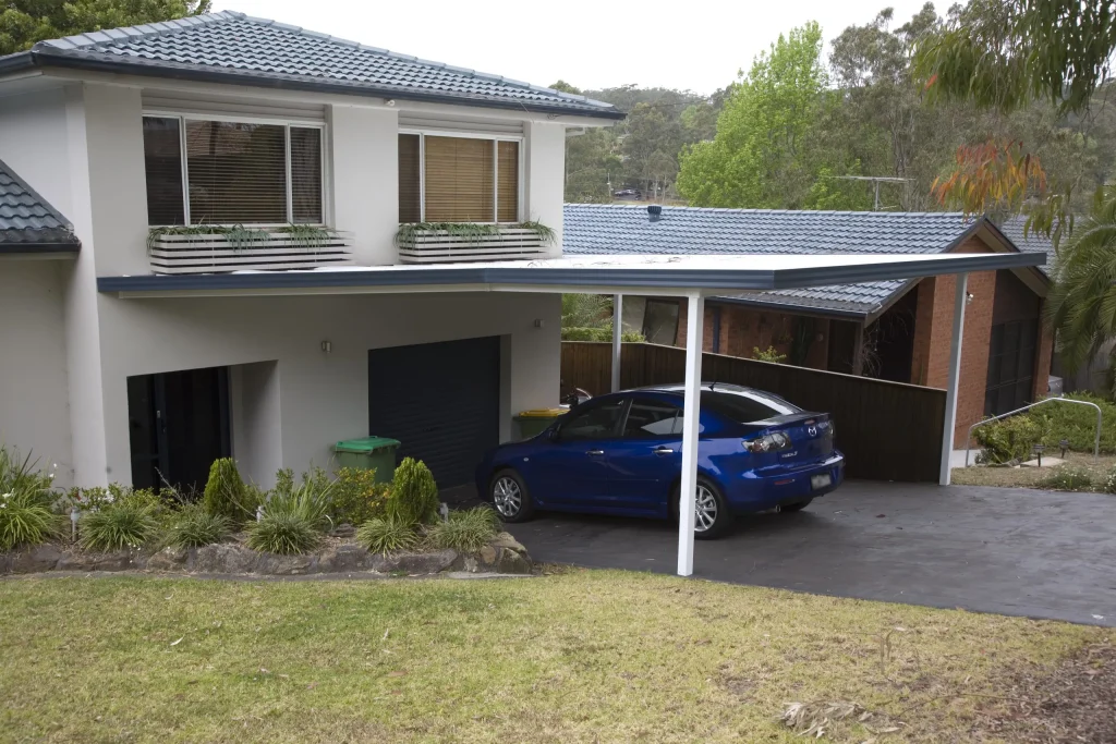 Blue car parked in modern carport.