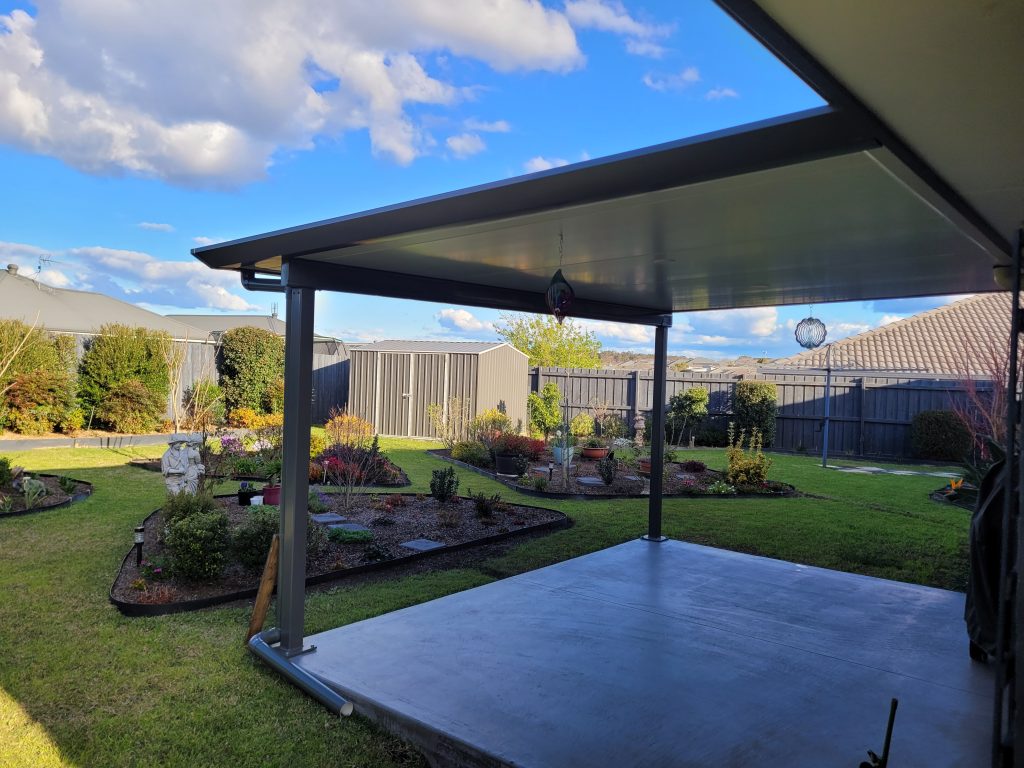 Backyard garden view with covered patio.