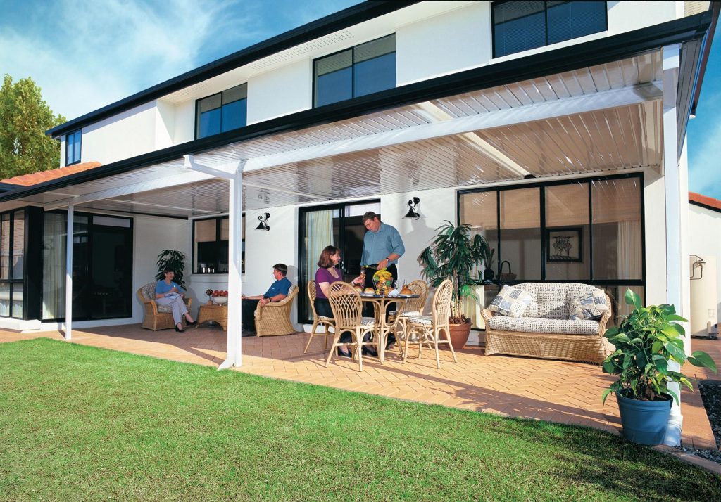 Backyard gathering on a covered patio with furniture.