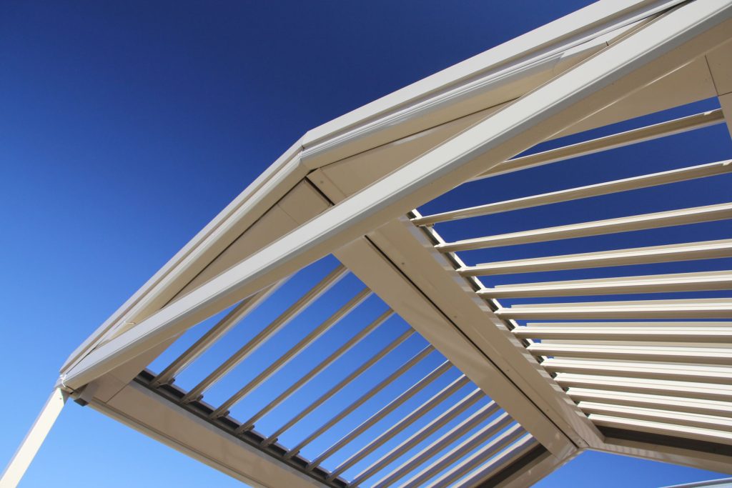 Modern pergola with slatted roof against blue sky
